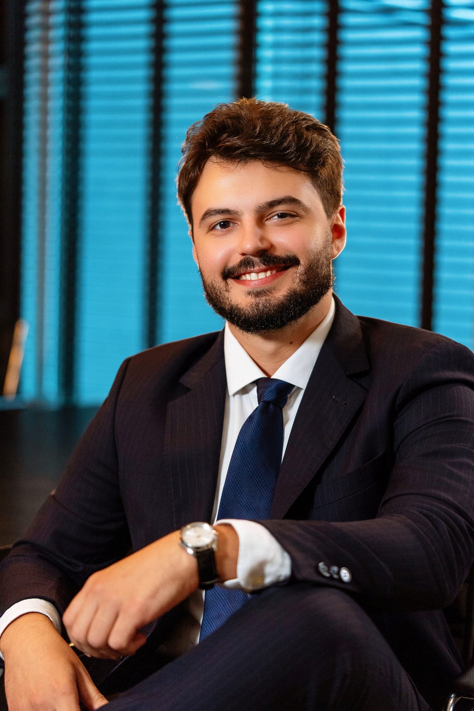 Advogado sorrindo, sentado no escritório – FNDL Advogados